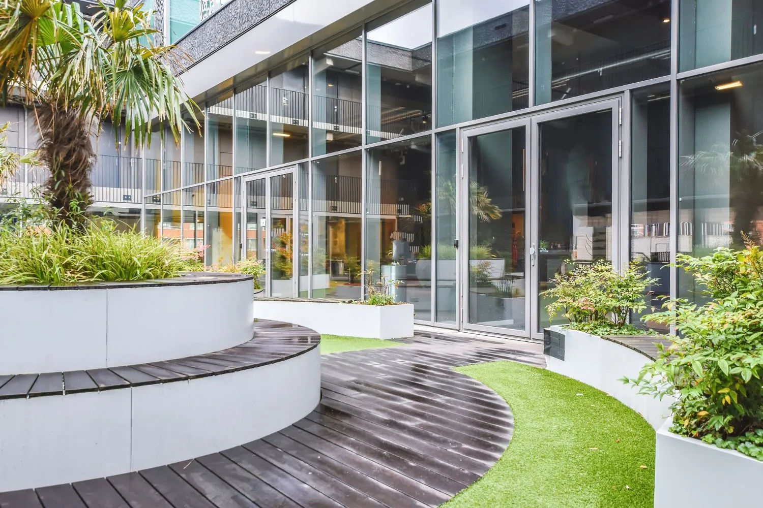 A large building with a lot of windows and a garden in front of it.