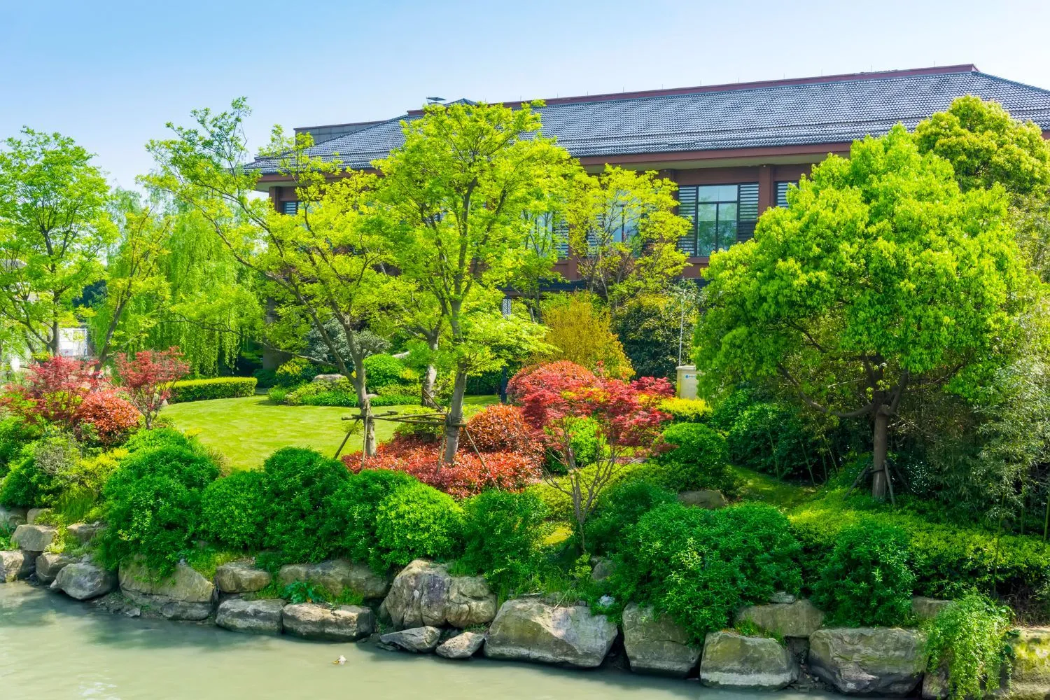 A large house is surrounded by a lush green garden.