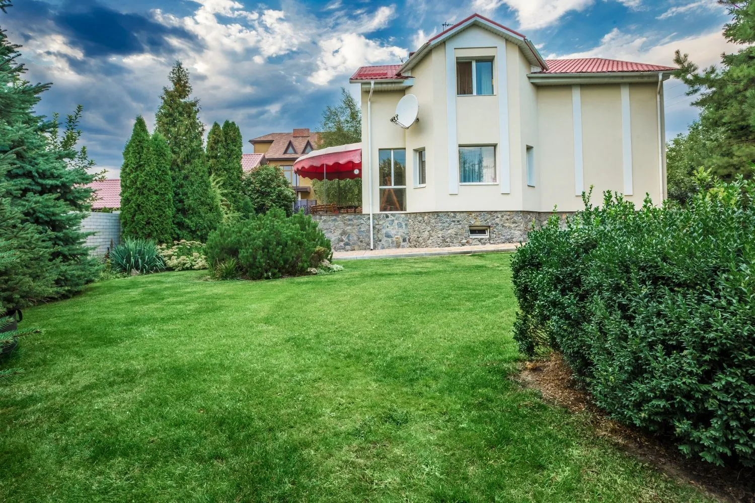 A large white house with a lush green lawn in front of it.
